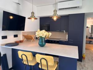 a kitchen with a counter with chairs and a vase of flowers at Barco - casa con jardín privado frente al mar in Mareny Barraquetas +12 photos