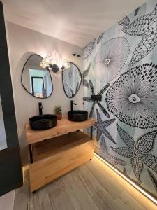a bathroom with two sinks and mirrors on a wall at Barco - casa con jardín privado frente al mar in Mareny Barraquetas