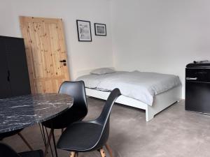 a bedroom with a bed and two chairs and a table at Rybka living apartments in Přerov