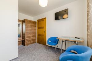 a room with a table and two blue chairs at Złota 24 in Karwia