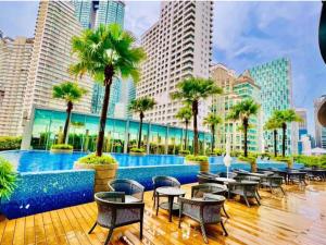 吉隆坡vortex suites klcc by twin tower vibes的酒店庭院设有桌椅,棕榈树