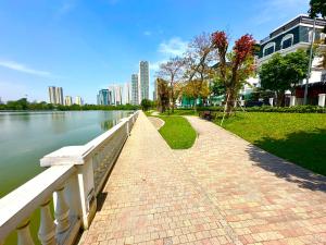a walkway next to a river next to a city at High Quality Studio In Vinhomes Green Bay Near My Dinh And Keangnam in Hanoi