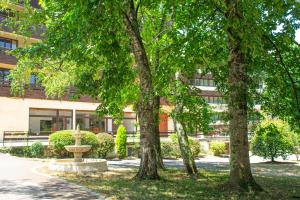 a building with trees and a fountain in front of it at Garden & City Capvern-les-Bains in Capvern +15 photos