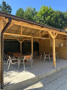a wooden pavilion with wooden tables and chairs at Casa Steluta de Mare in 2 Mai +7 photos
