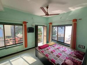 a bedroom with a bed and a ceiling fan at holiday homes in Murud +15 photos