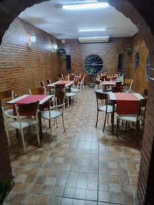 a dining room with tables and chairs and a brick wall at Hotel las ruedas by Choca in Arroyito +14 photos