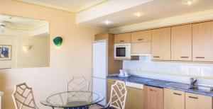 a kitchen with a table and a white refrigerator at Apartamento superior con balcon en Bahia Feliz in Playa del Aguila