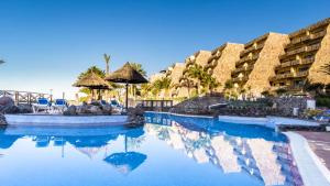 a swimming pool at a resort with blue water at Apartamento superior con balcon en Bahia Feliz in Playa del Aguila +1 photo