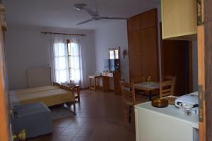 a kitchen and living room with a table and chairs at Hostel Gerakina ΙΙ in Vávdhos