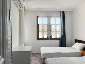 a room with two beds and a window at Kaptan Pansiyon in Kaş