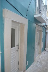a building with white doors and a balcony at Portu Sereno Apartments in Setúbal +55 photos