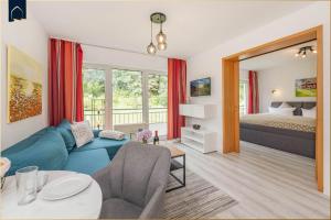 a living room with a blue couch and a bed at Maxim-Gorki-Straße Whg Kranich in Bansin