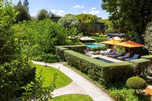 ein Garten mit Swimmingpool und Sonnenschirmen in der Unterkunft The Peech Hotel in Johannesburg