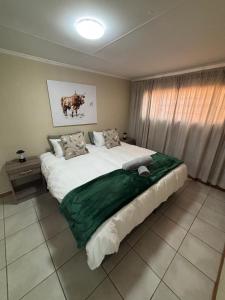 a large bed in a room with a large window at The Hideaway at Roggeveld in Kimberley +11 photos