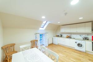 a kitchen with white cabinets and a table and chairs at Penninghame Estate - Wallace Apartment in Challoch