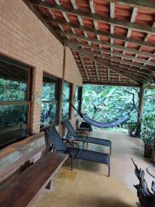 a porch with two chairs and a wooden table at Casa de praia e campo Barra do Una Canto dos Tiês in São Sebastião +24 photos