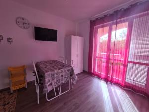 a room with a bed and a window with pink curtains at Emanuela Appartaments in Furnari