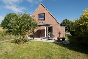 a brick house with a patio with an umbrella at Landhaus Ostseeglück in Dahme +37 photos