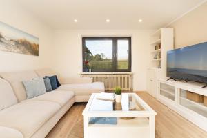 トムスドルフにあるLandhaus Ostseeglückの白いソファと薄型テレビのあるリビングルーム