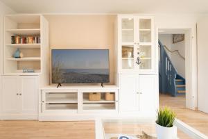 トムスドルフにあるLandhaus Ostseeglückのリビングルーム(白いエンターテイメントセンター内のテレビ付)