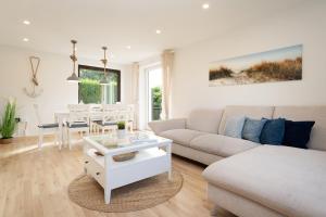 トムスドルフにあるLandhaus Ostseeglückのソファとテーブルのある白いリビングルーム