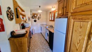 a kitchen with a white refrigerator and a sink at Chalet l Houtot in Evolène