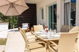 a wooden table with chairs and an umbrella on a patio at Villa Elena Coral in Peyia