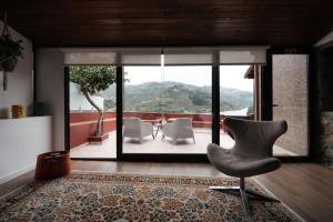 a living room with a chair and a table at Refúgio do Barqueiro - Douro in Mesão Frio