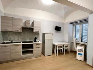 a kitchen with a white refrigerator and a table at Booking House Rome in Rome