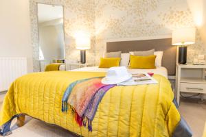 a yellow bed with a hat on top of it at Mulranny Park Hotel in Mulranny