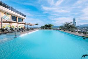 a large swimming pool on the roof of a building at Holiday Inn Lampung Bukit Randu by IHG in Bandar Lampung