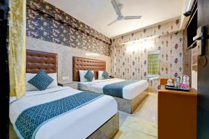 a bedroom with two beds in a room at Hotel Paradise Classic At Airport in New Delhi