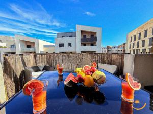 a blue table with fruit on top of a balcony at Védas Prestige, Tout confort in Saint-Jean-de-Védas