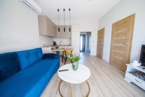 a living room with a blue couch and a table at Pajūrio Poilsis in Palanga