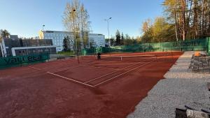 a tennis court with a player on it at Jumara Apartment in Valmiera
