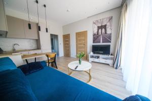 a living room with a blue bed and a table at Pajūrio Poilsis in Palanga