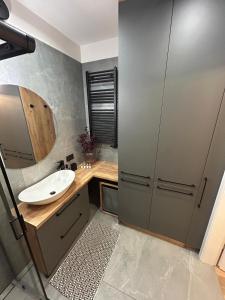 a bathroom with a sink and a mirror at Loft & City MANUFAKTURA in Łódź