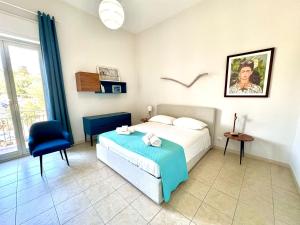 a bedroom with a bed and a blue chair at CalmaHouse in Capo Mulini
