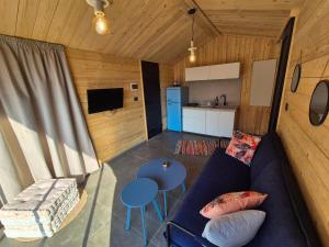 a living room with a blue couch and a kitchen at Faraya Vista in Kfardebian