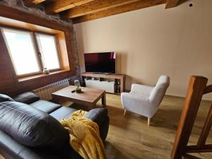 a living room with a couch and a tv at Villanueva 5 in Luces