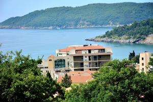 贝西奇SeaWolf Apartment的水体旁的山丘上的建筑物