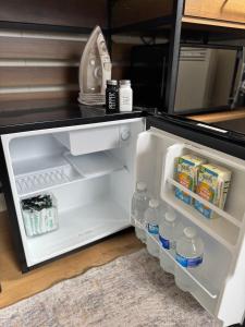 an open refrigerator filled with milk and water at The Snug in Yeovil