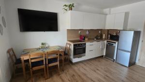 a small kitchen with a table and a refrigerator at Lexa Apartment in Sklenárovo