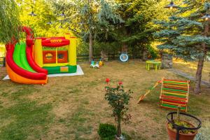 a playground with a slide in a yard at Дедовата Къща in Dedovo