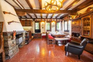 a living room with a stone fireplace and a table at Дедовата Къща in Dedovo