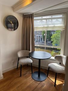 a table and two chairs in a room with a window at Boutique LaBeau in Amsterdam +1 photo