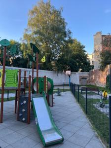 a playground with a slide in a park at Loft & City MANUFAKTURA in Łódź +5 photos