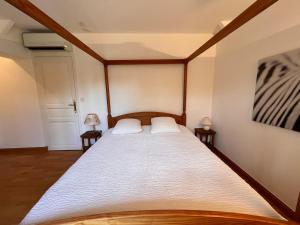 a bedroom with a large bed with two night stands at Domaine en Sologne Piscine chambre Climatisée in Nouan-le-Fuzelier +3 photos