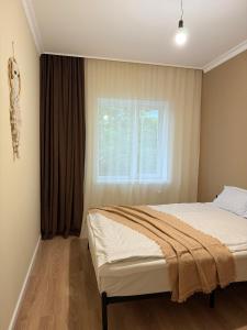 a bedroom with a bed and a window at DendroBak GuestHouse in Stepʼanavan