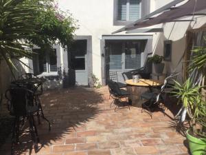 a patio with a table and chairs on a brick floor at Castel&Letti in Agde
